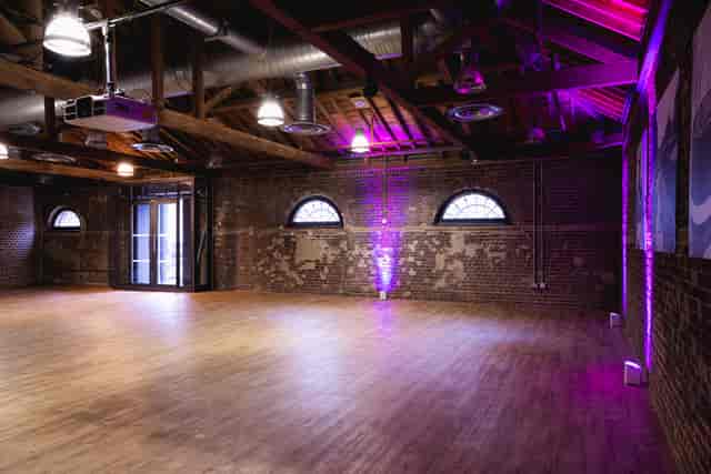 Quayside Room at London Museum Docklands, rustic event space with purple lighting.