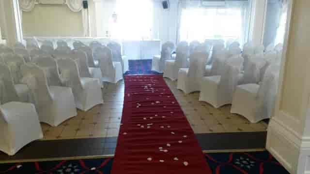Elegant wedding event space in The Yacht Club with white chairs and red carpet.