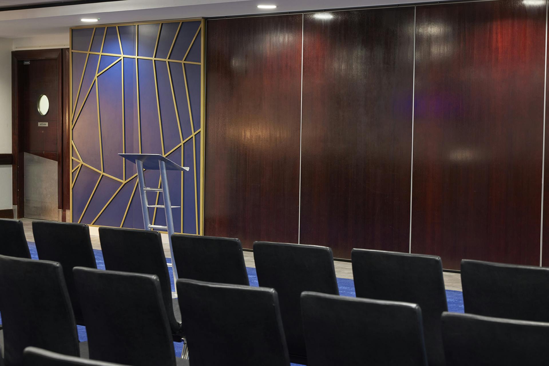 Modern meeting space at Chelsea FC, featuring a sleek podium for conferences and workshops.