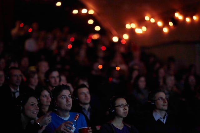 Engaged audience at The Vaults Theatre during an immersive multimedia event.