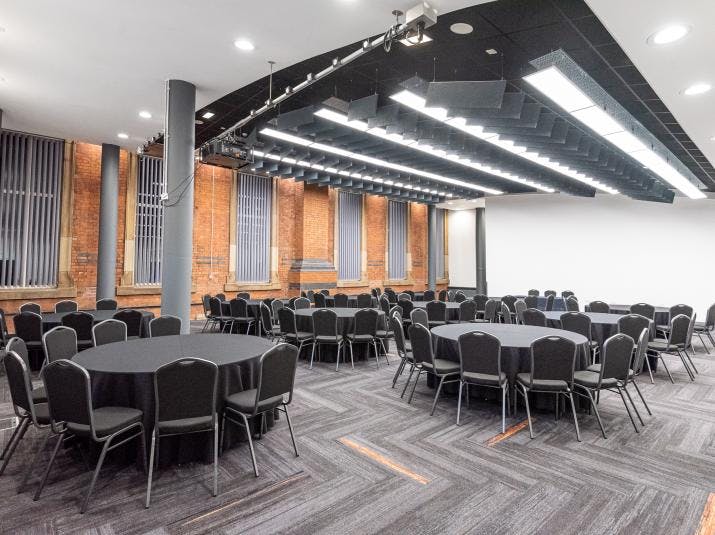 Exchange Hall in Manchester Central, modern event space with round tables for banquets and conferences.