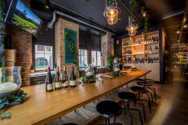 Stylish venue with wooden table, ideal for corporate events and intimate gatherings.