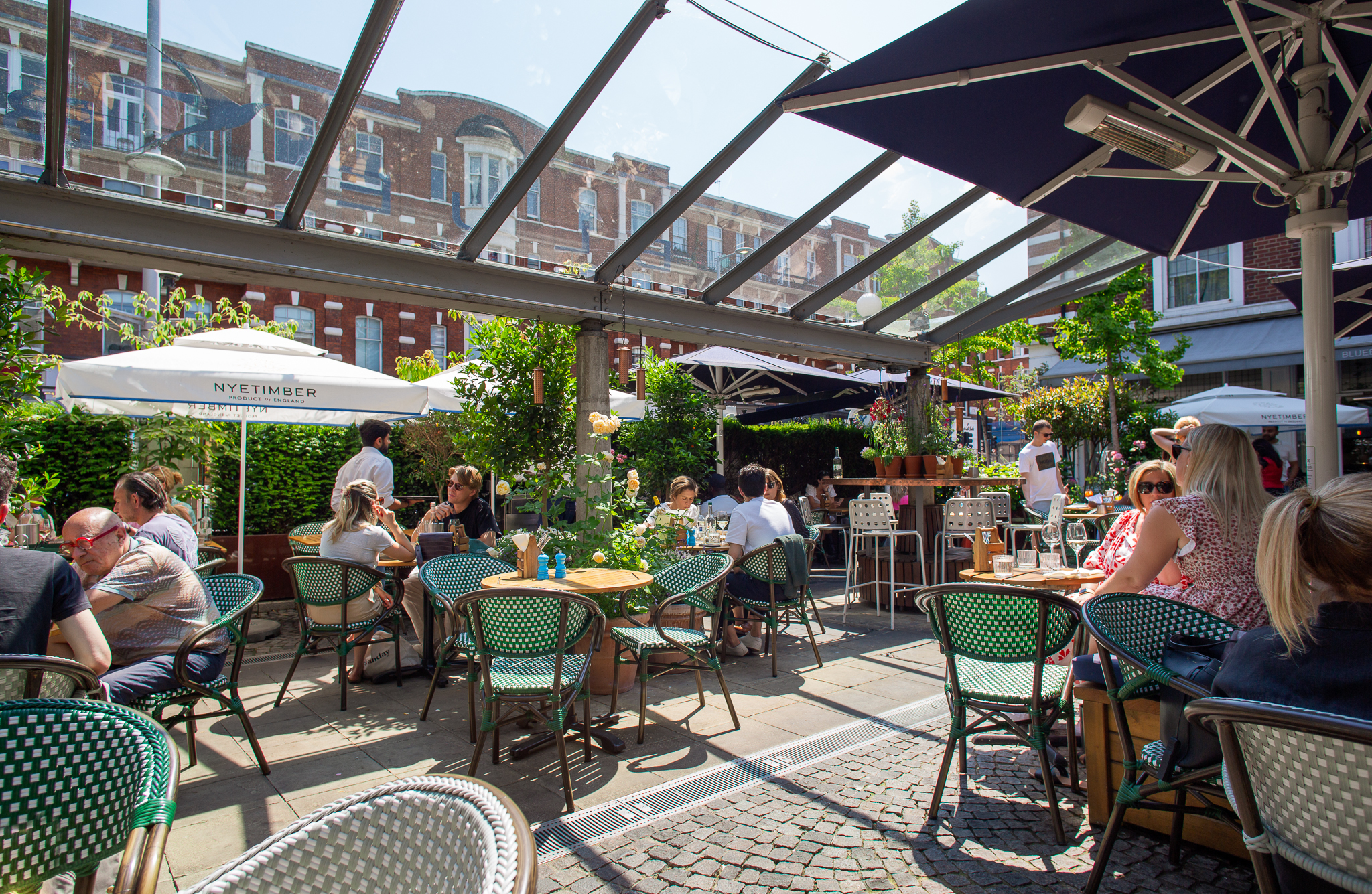 Vibrant outdoor café in Bluebird Chelsea, ideal for casual meetings and networking events. - Banner