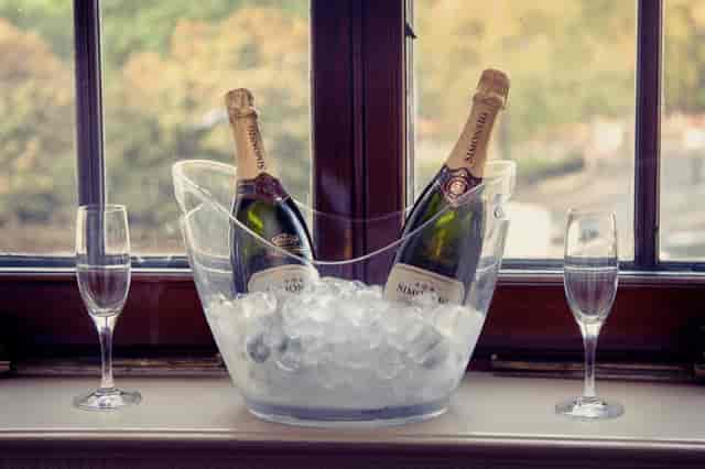 Stylish ice bucket with champagne and flutes, perfect for weddings or corporate events.