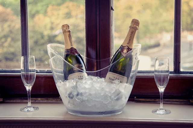 Stylish ice bucket with champagne and flutes, perfect for weddings or corporate events.