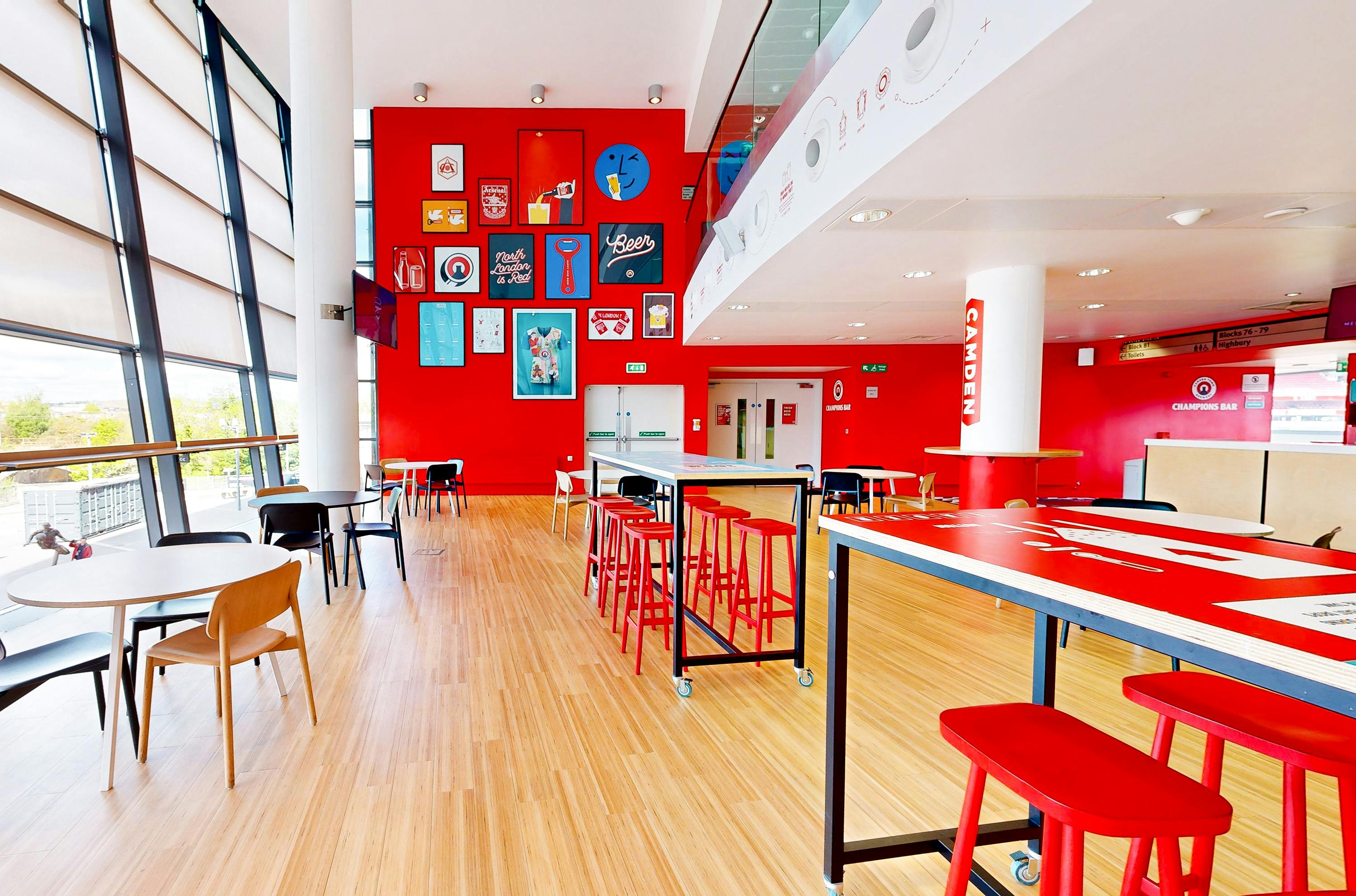 Champions at Arsenal FC: modern event space with red walls for networking and gatherings.