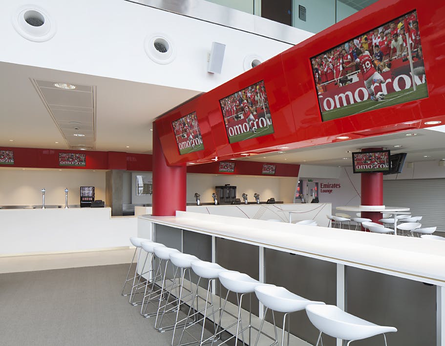 Emirates Lounge at Arsenal Stadium, modern event space with vibrant red accents.