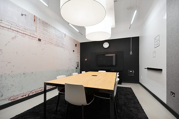 Modern meeting room with wooden table, ideal for collaborative brainstorming sessions.