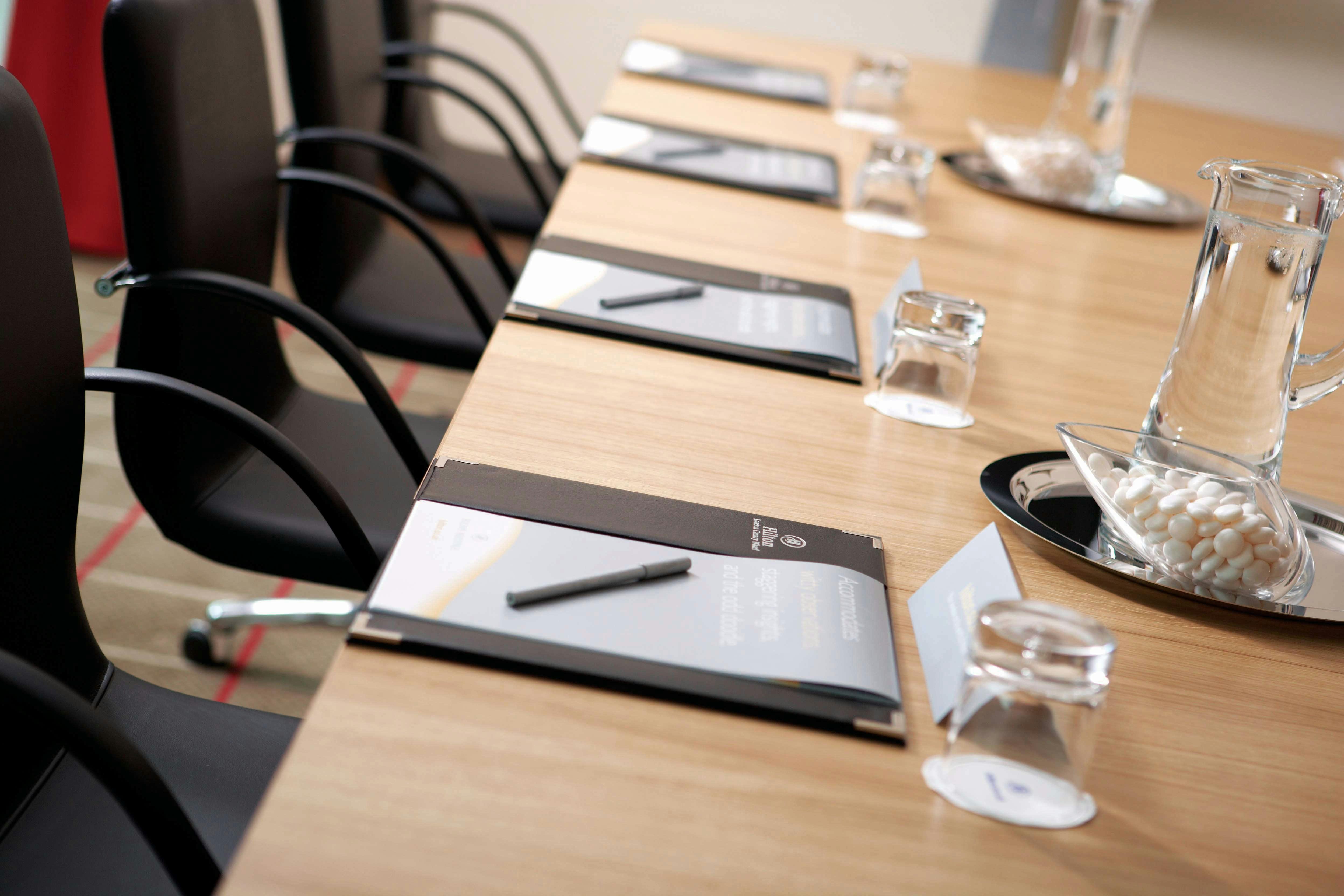 Quayside suite meeting setup at Hilton London Canary Wharf with polished wooden table.