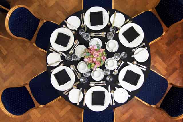 Presidential Suite table set for elegant corporate event with flowers and black napkins.