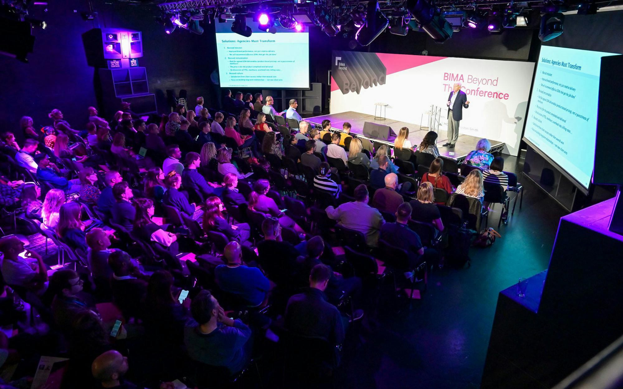 Conference speaker engaging audience in The Box, Ministry of Sound, with dynamic lighting.