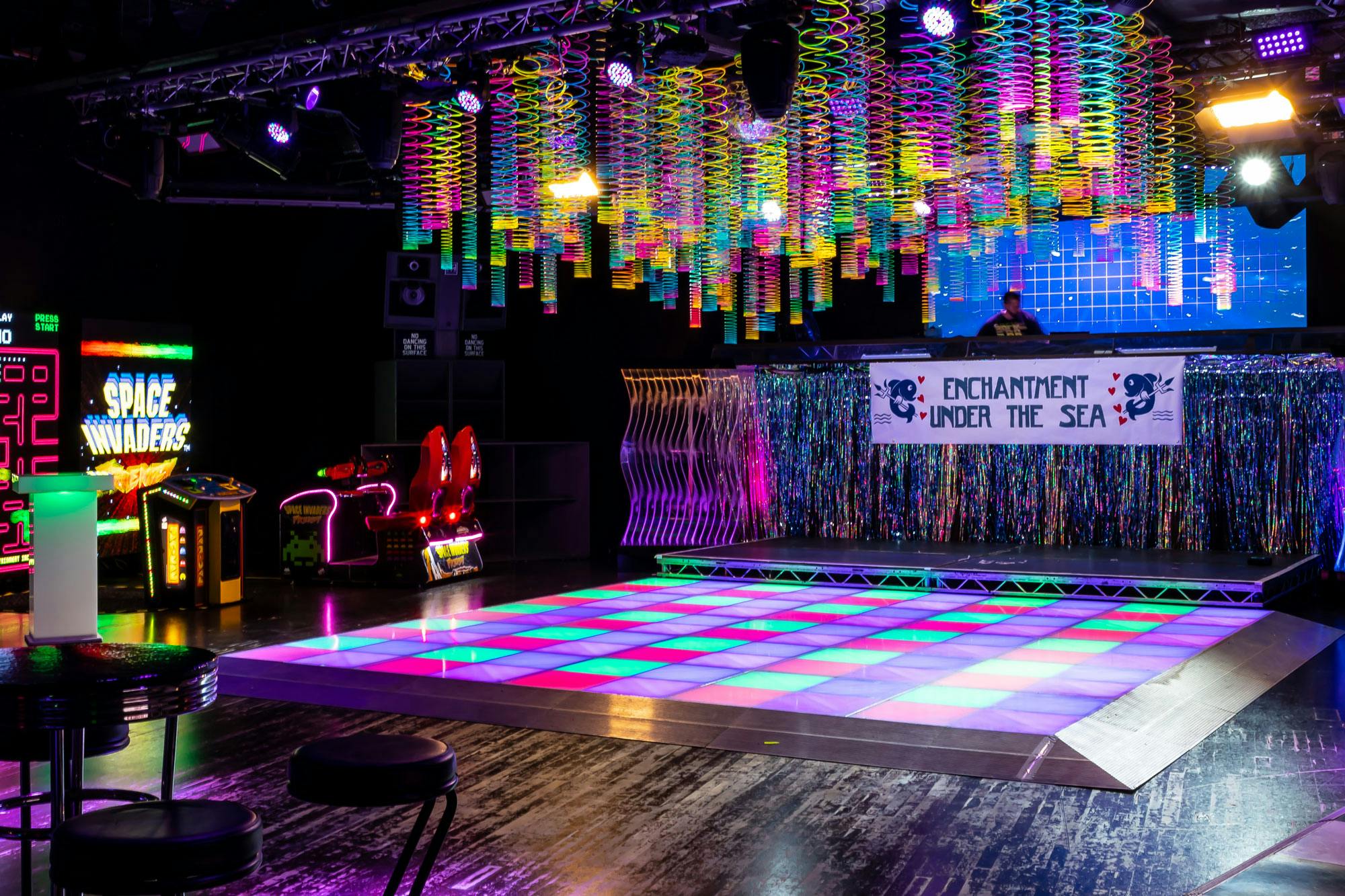 Vibrant underwater-themed party space at The Box, Ministry of Sound, with colorful lighting.