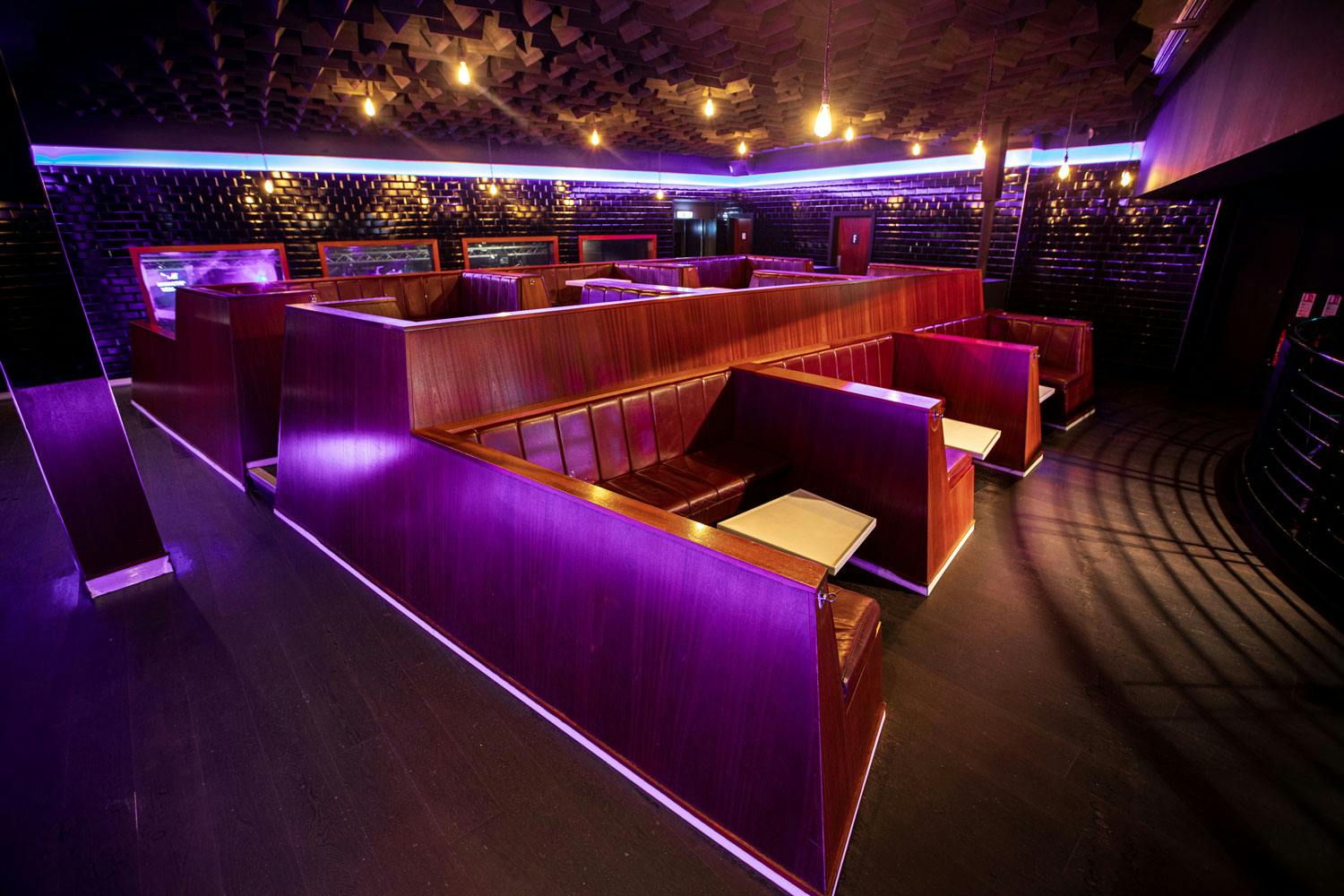 Modern event space with purple lighting, perfect for networking and social mixers.