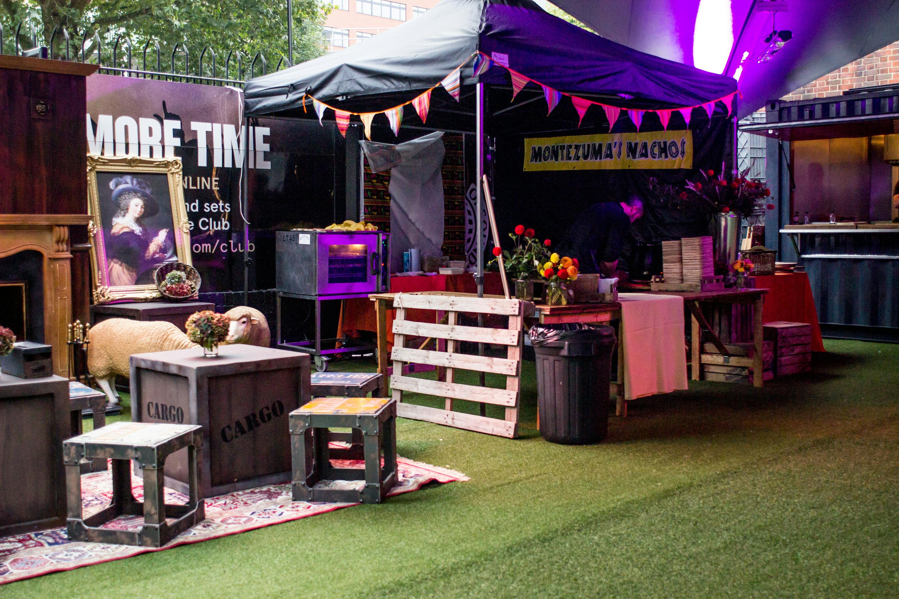 Vibrant outdoor event space at Ministry of Sound with colorful bunting and rustic furniture.