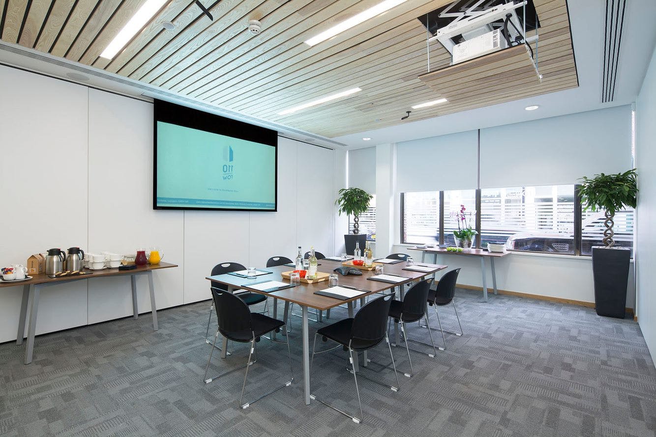 Modern meeting room with large screen, ideal for corporate workshops and collaboration.