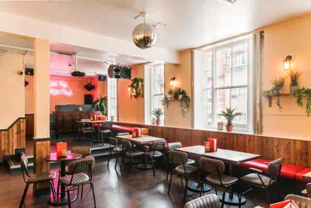Vibrant event space with flexible seating and disco ball for gatherings and workshops.