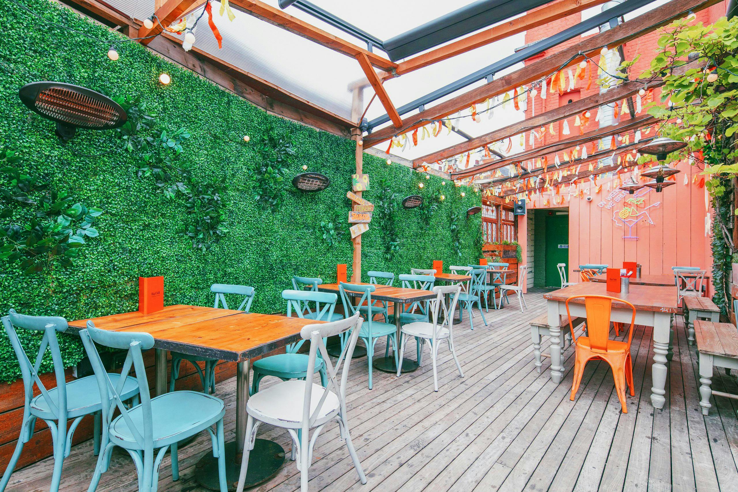 Vibrant outdoor event space with colorful seating and lush greenery for gatherings.