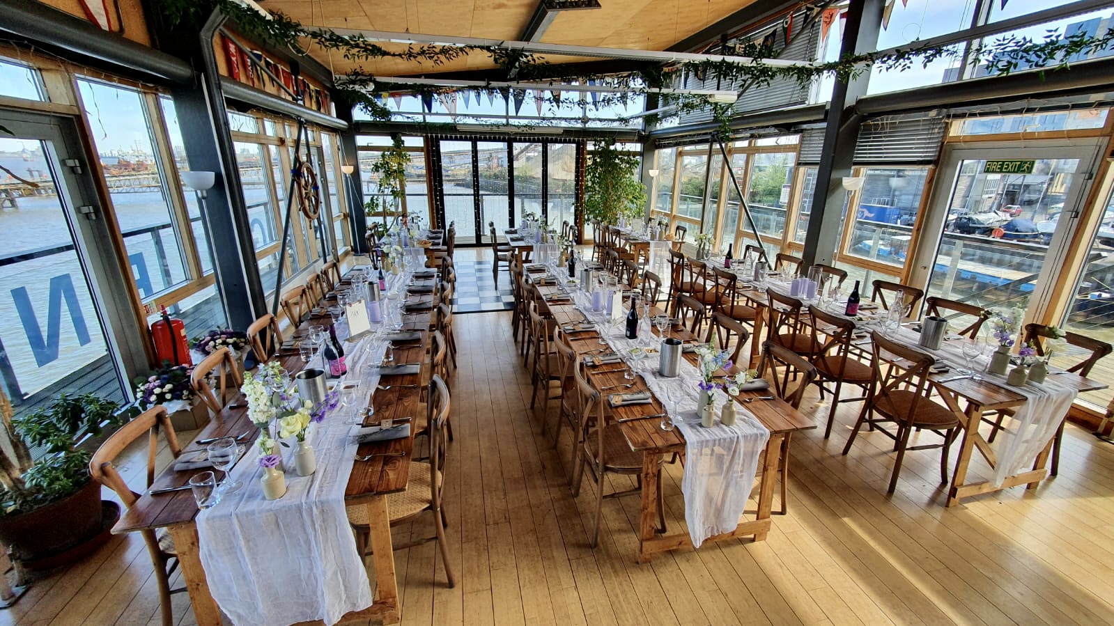 Elegant event space at Greenwich Yacht Club with floral centerpieces and waterfront view. - Banner