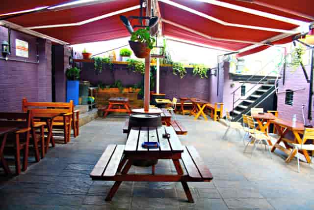 Covered outdoor venue with picnic benches for networking events and team-building socials.
