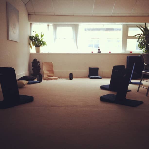 Serene workshop room with cushions for mindfulness and wellness sessions.