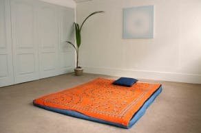 Minimalist workshop room with vibrant orange-blue floor for creative retreats.