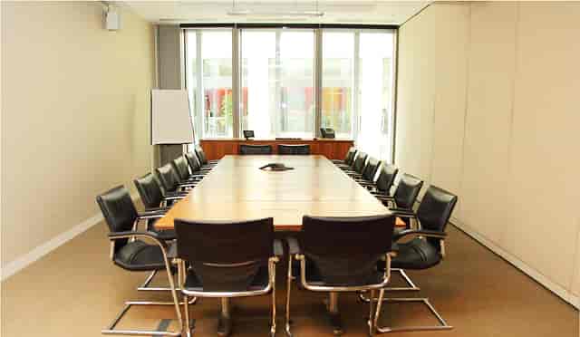 Modern conference room in London Stock Exchange, featuring a large wooden table for meetings.