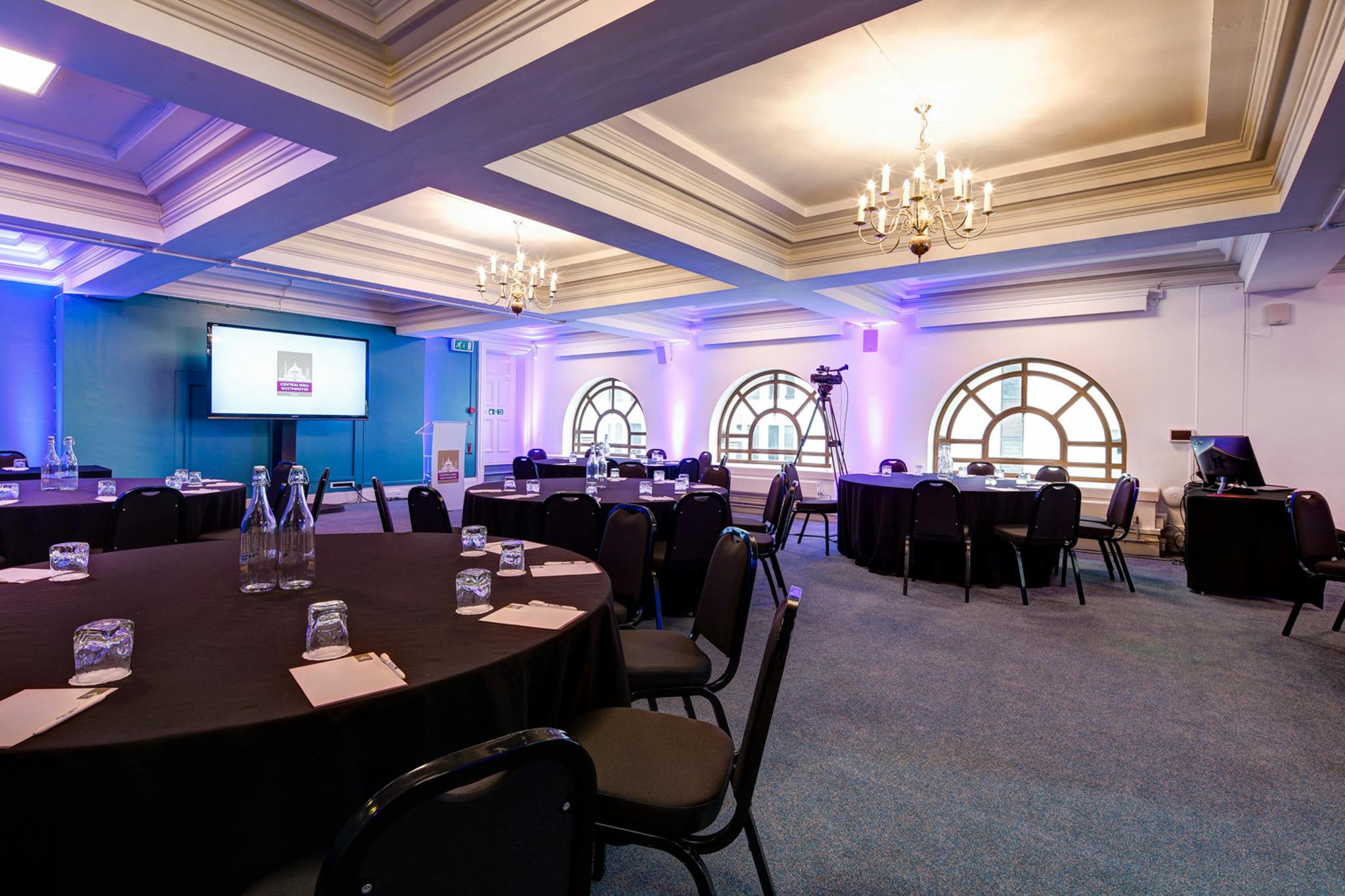 Donald English in Central Hall Westminster, elegant conference setup with round tables.