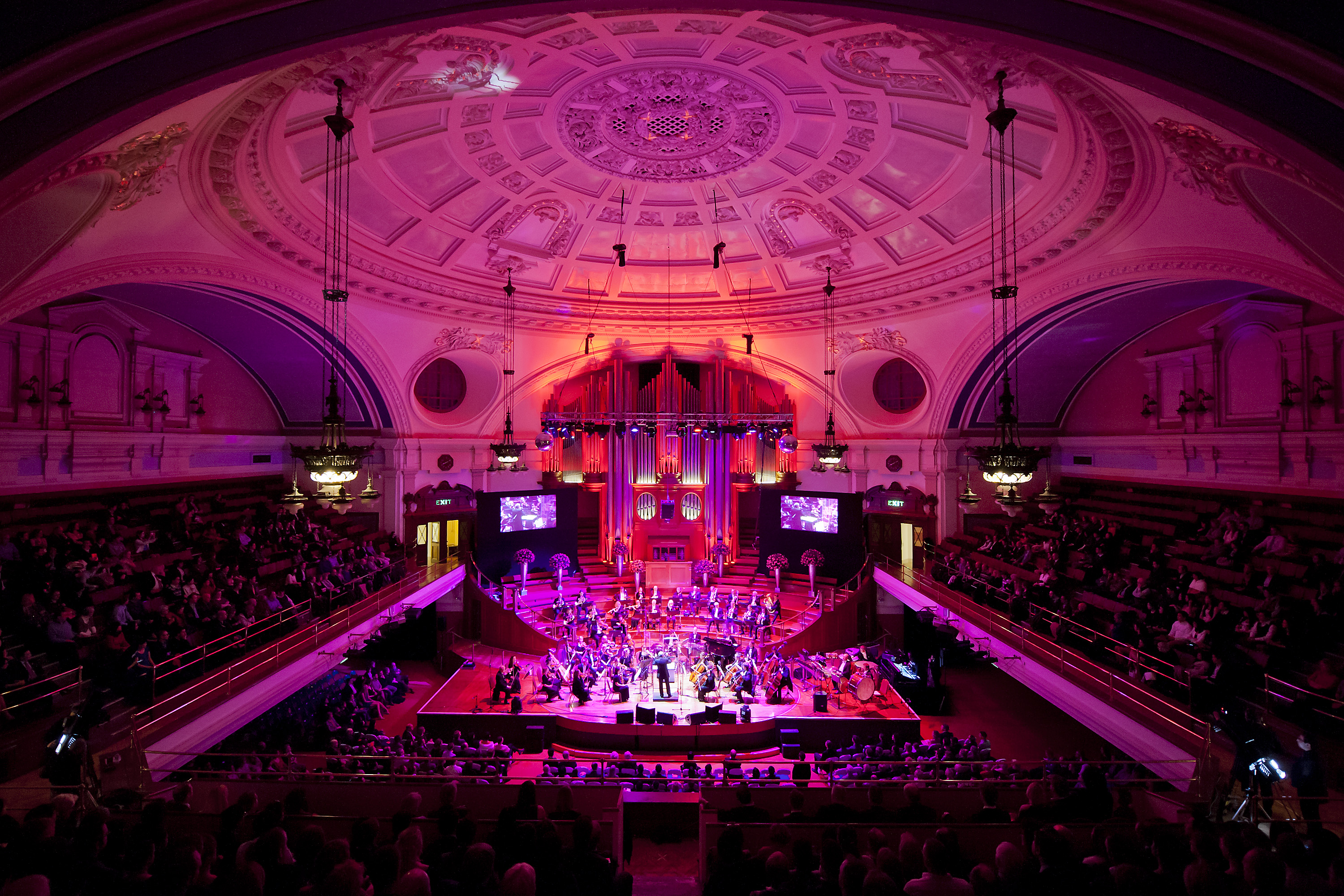 Great Hall Westminster concert with vibrant lighting and ornate architecture. - Banner
