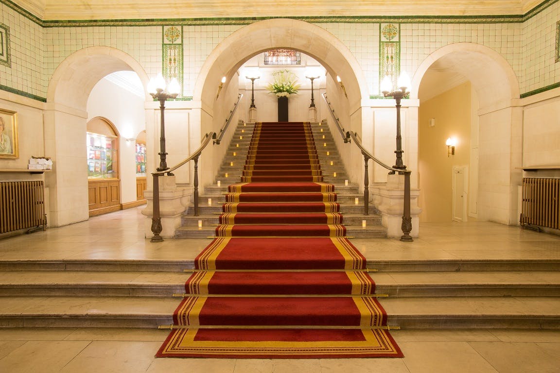 Elegant staircase with red carpet in The Common Room, ideal for formal events.