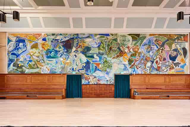 Kennedy Hall at Cecil Sharp House, spacious venue with vibrant mural for events.