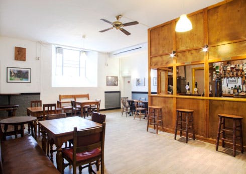 Versatile event space at Cecil Sharp House with wooden furniture for networking events.