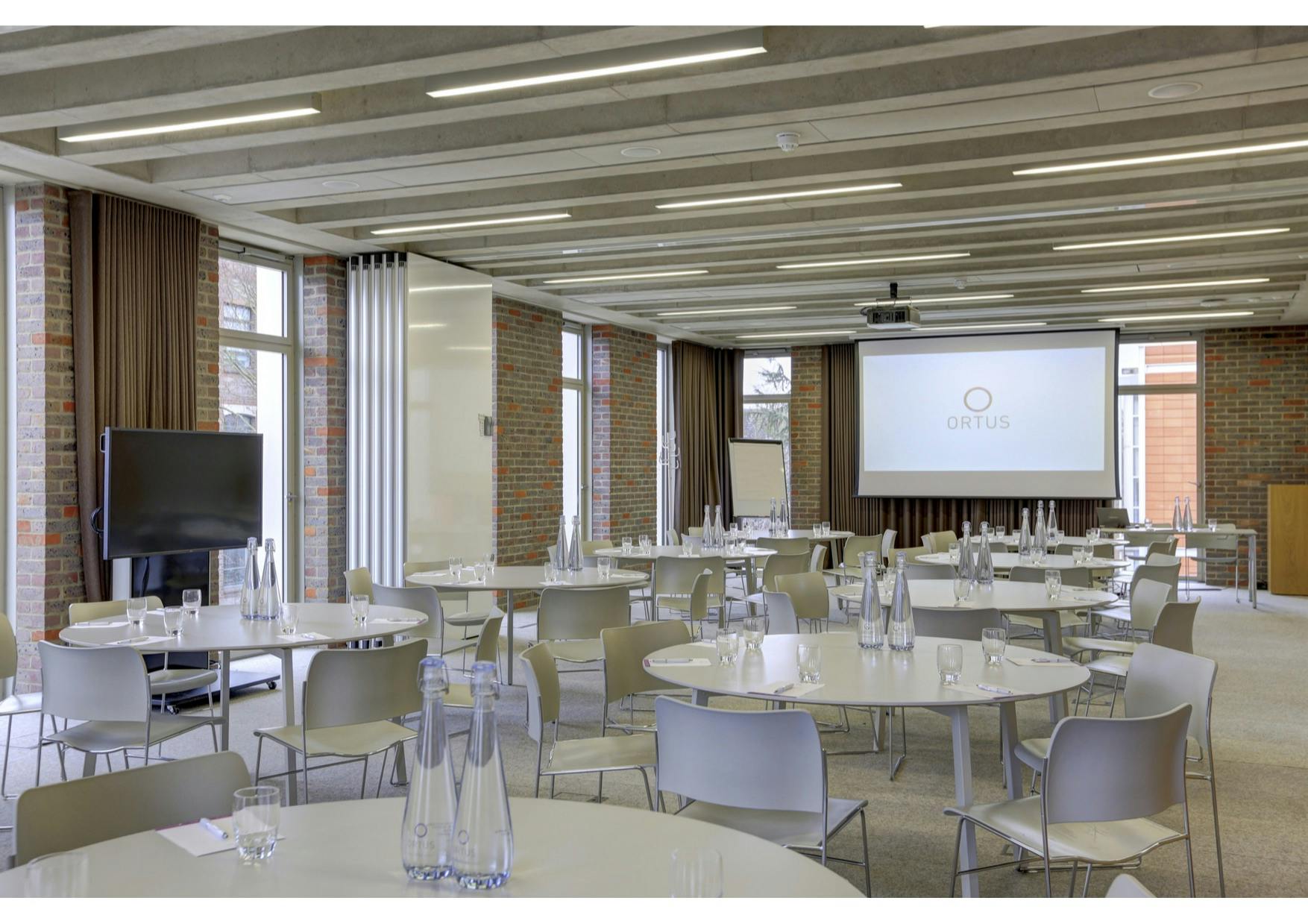 Modern meeting space with round tables at ORTUS Conference for corporate events.