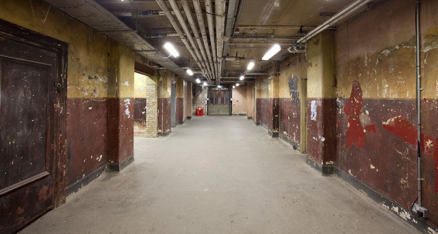 Dimly lit industrial corridor in Shoreditch Town Hall for creative events and gatherings.