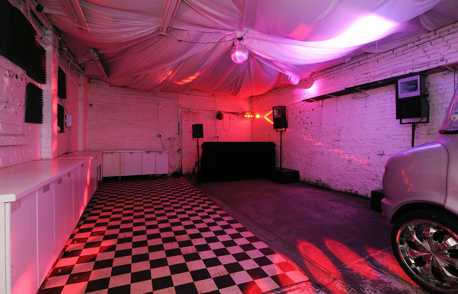 Versatile event space with checkered floor, ideal for live performances and gatherings.