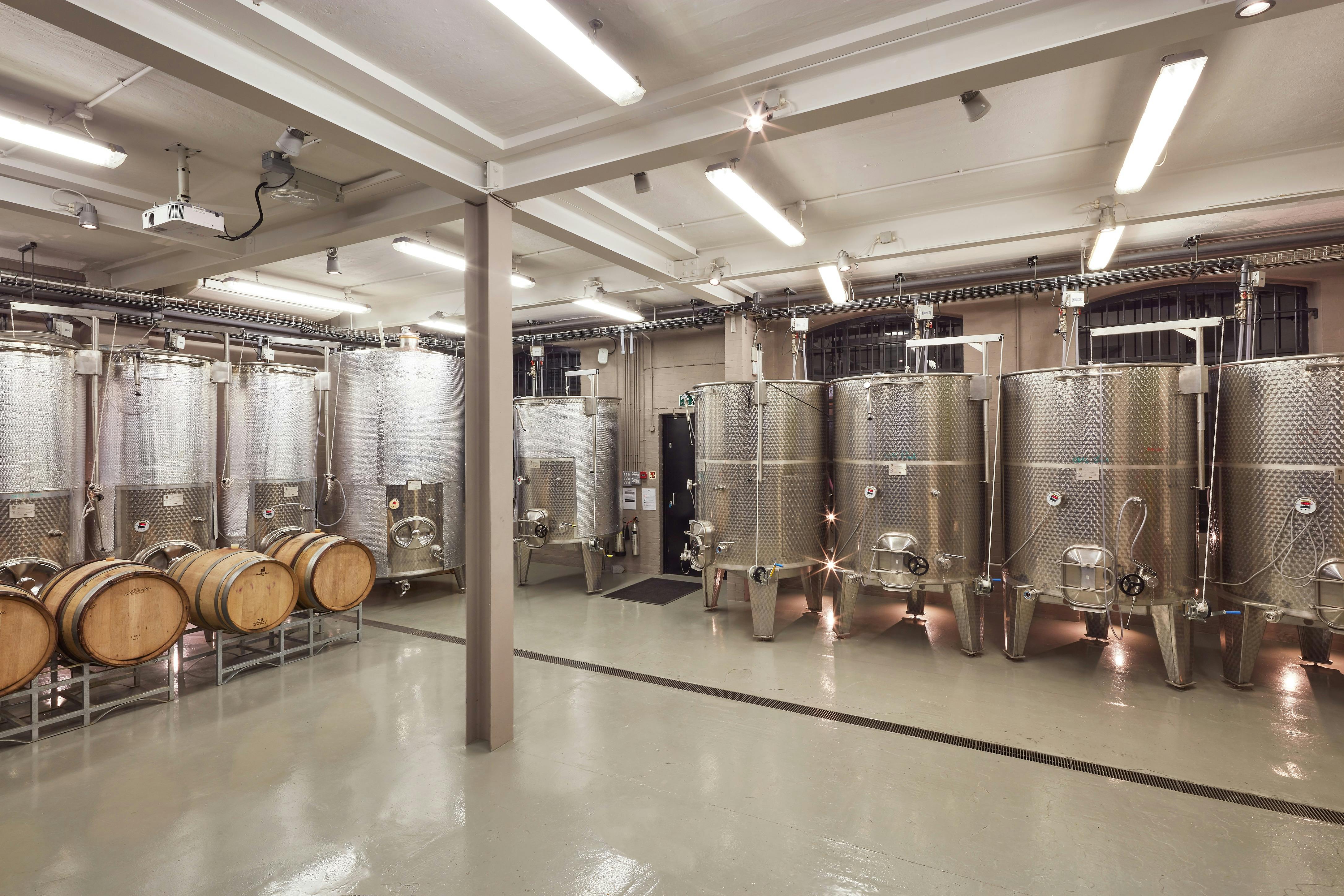 Modern winery venue with stainless steel tanks, ideal for corporate retreats and wine tastings.