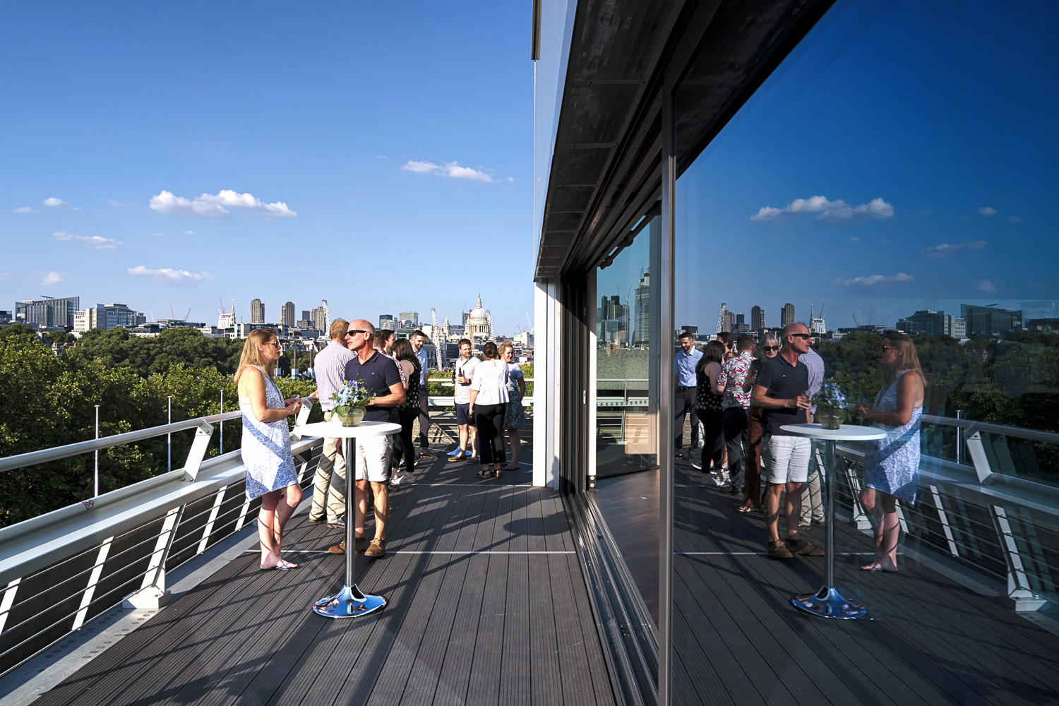 Vibrant outdoor networking event on Buffini Chao Deck with city skyline backdrop. - Banner