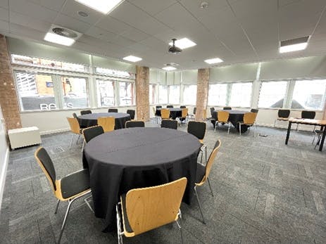 Versatile meeting space with round tables and natural light in Birmingham for events.