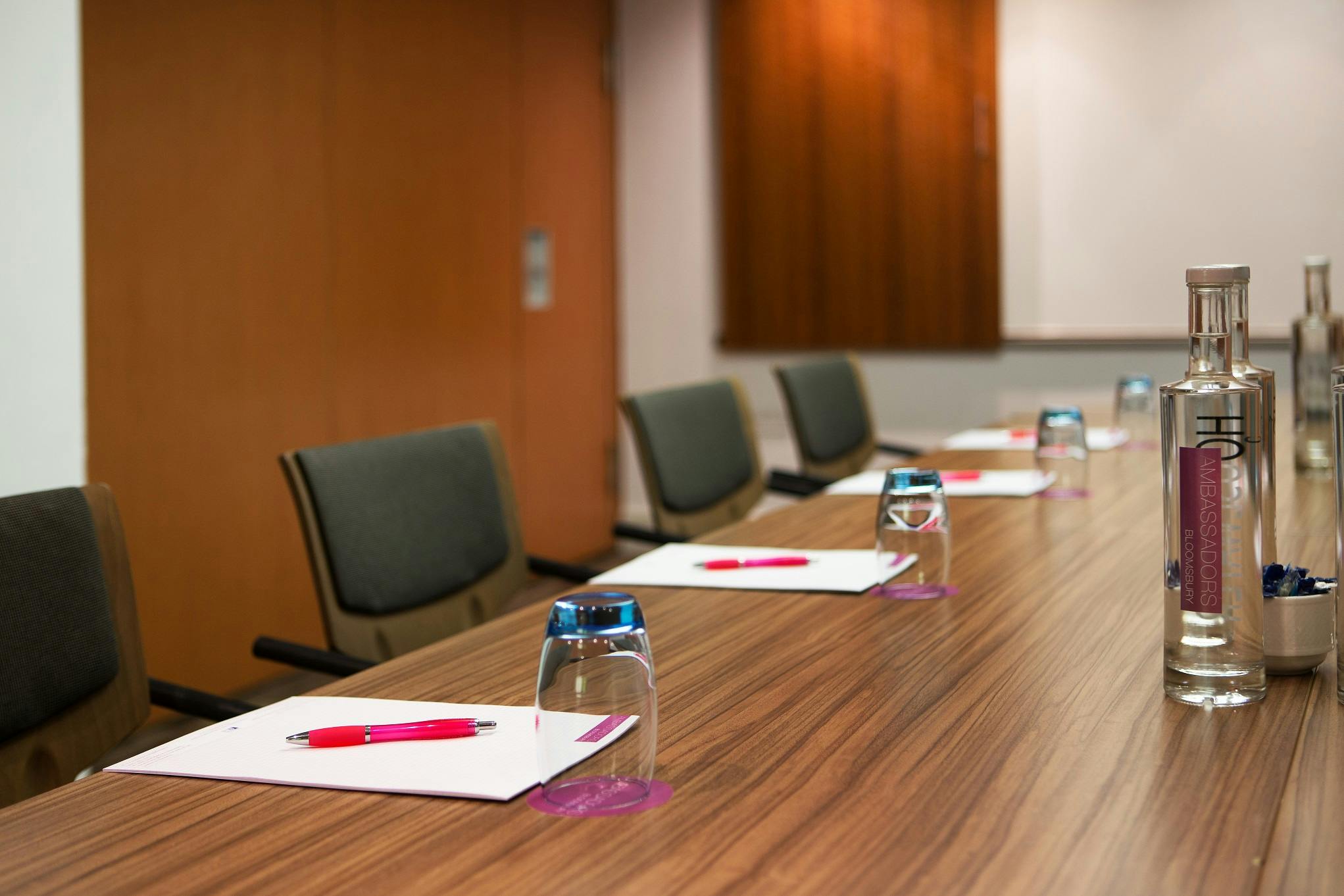 Innovate Suite meeting room with polished table, notepads, and warm lighting.