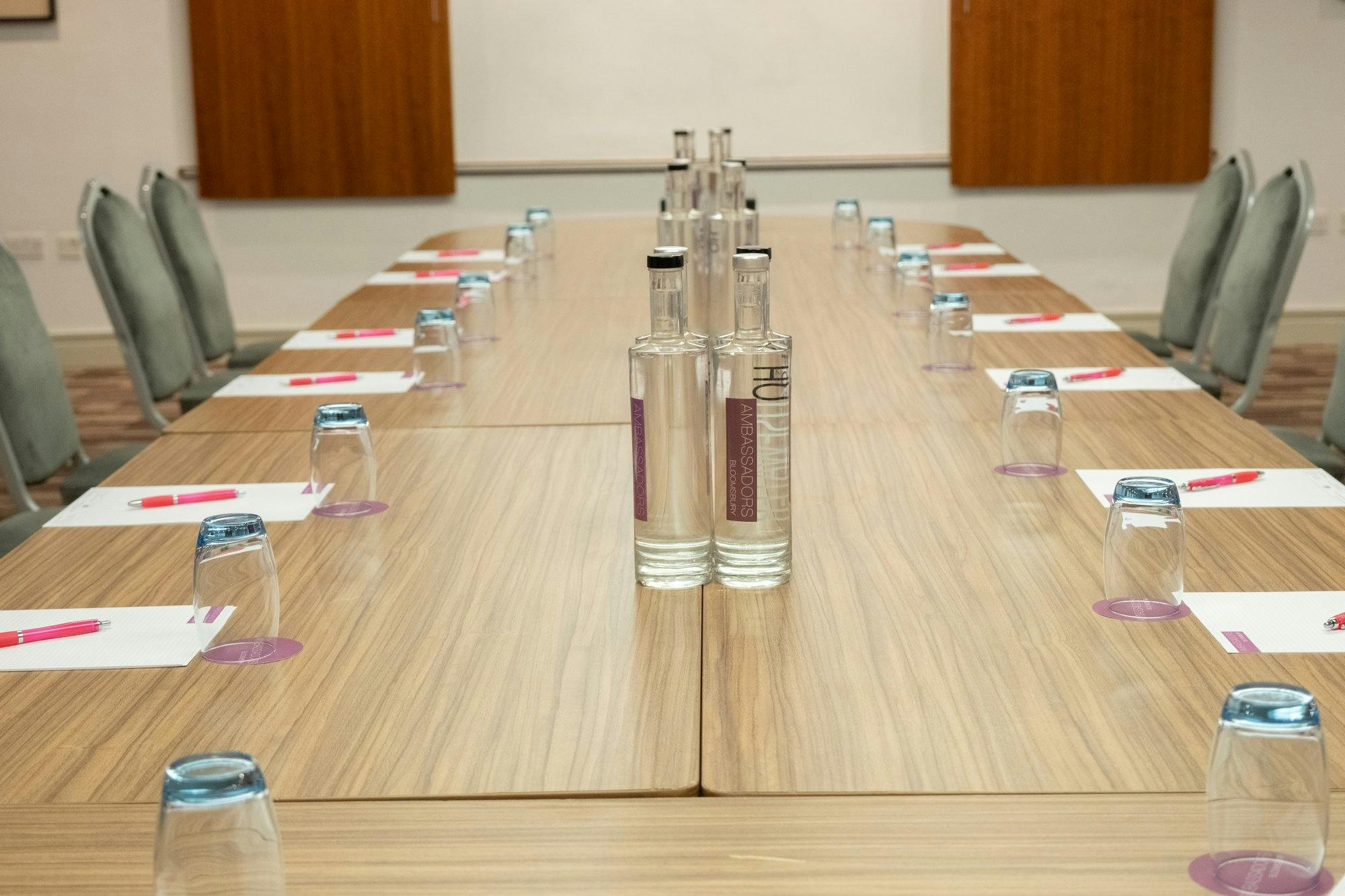 Innovate Suite meeting room with long table, notepads, and water bottles for events.