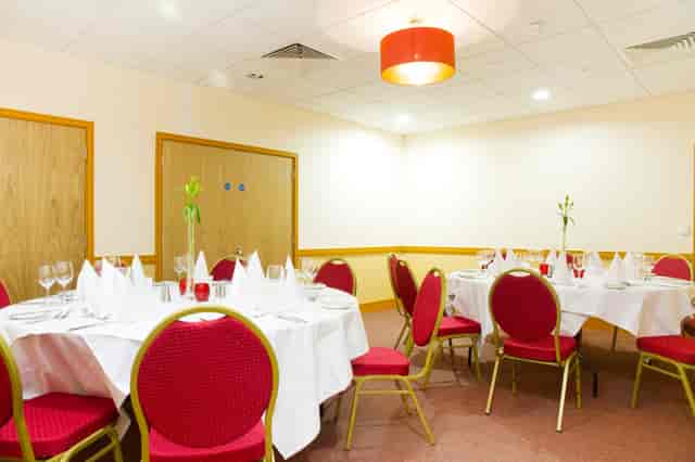 Excelsior Room banquet setup with red chairs for small meetings and private dining events.