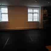 Minimalist rehearsal space with natural light for versatile workshops and meetings.