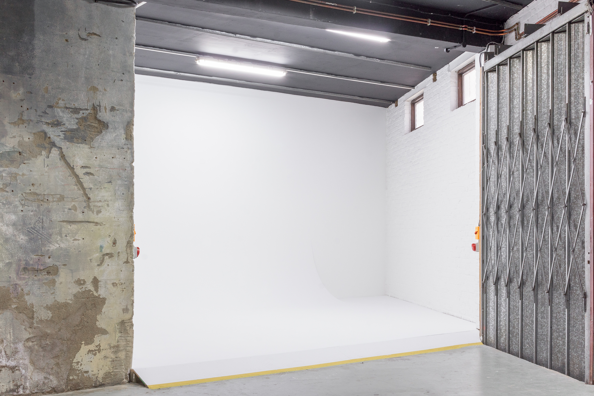 Versatile event space in Apiary Studios with minimalist backdrop for workshops and gatherings.