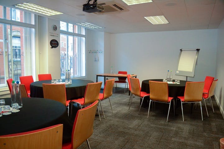 Versatile meeting space in Birmingham with round tables, ideal for workshops and collaboration.