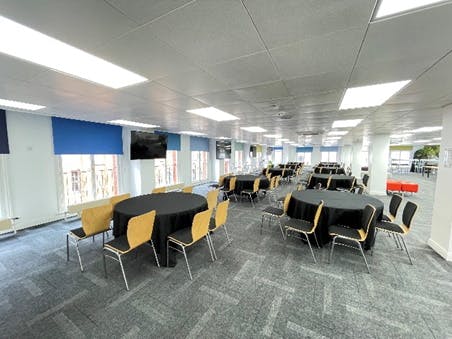 Versatile event space in Birmingham with round tables, ideal for meetings and workshops.