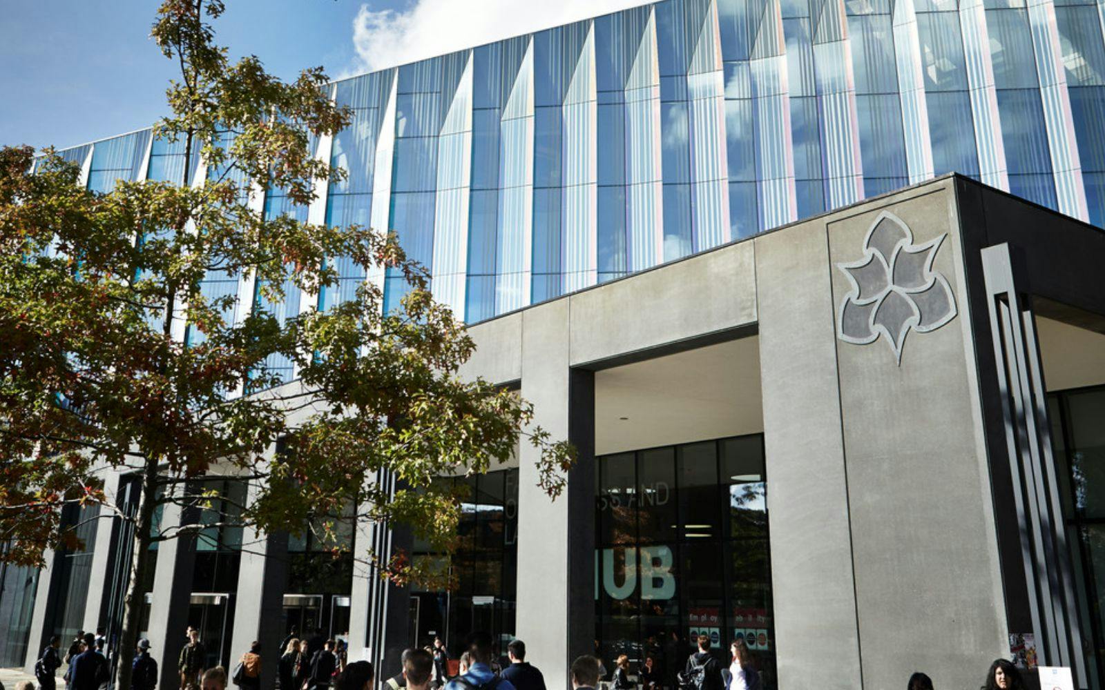 Modern business school meeting space with glass facade, ideal for conferences and gatherings.