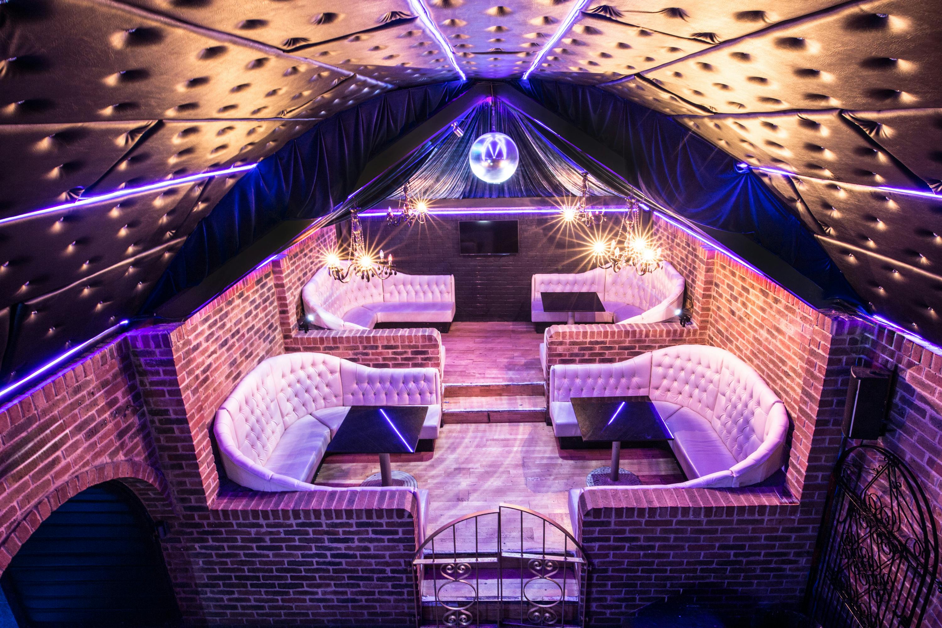 Stylish event space with plush seating and disco ball, perfect for parties and networking.
