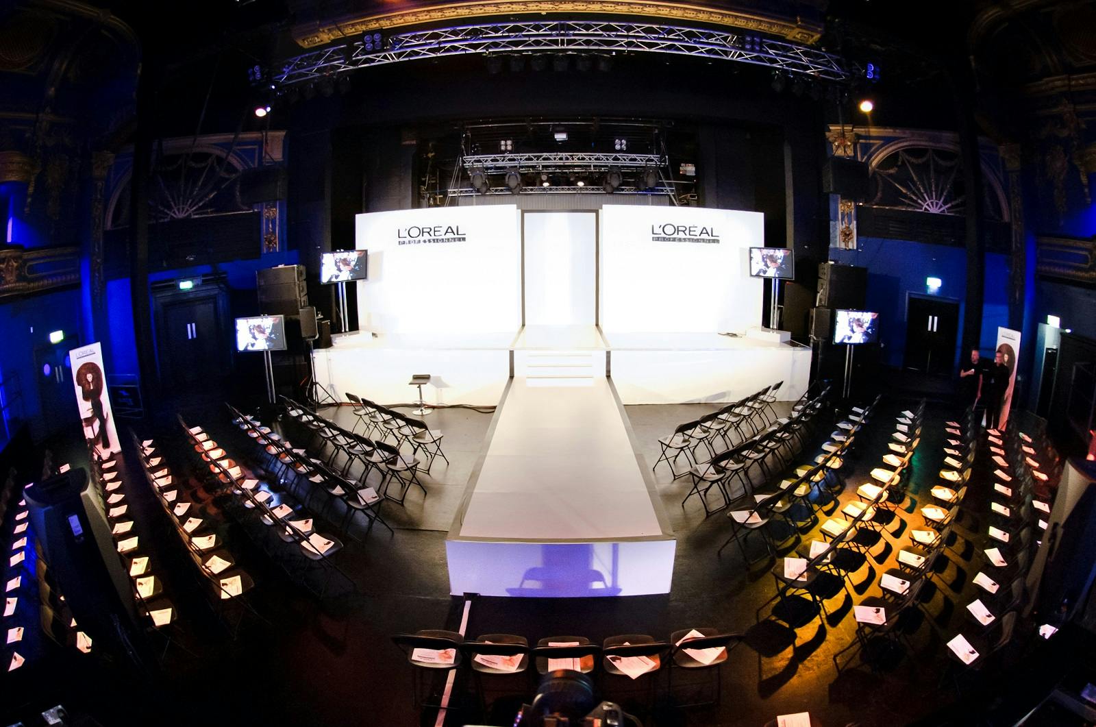 Electric Brixton fashion show setup with central runway and bright lighting.