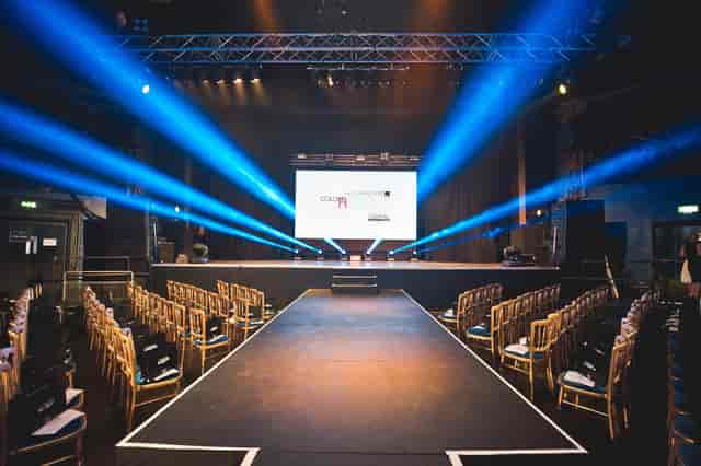 Electric Brixton event space with stage, blue lighting for corporate presentations.