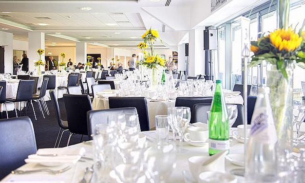 Elegant 1882 Suite at Edgbaston Stadium, set for formal networking events with sunflowers. - Banner
