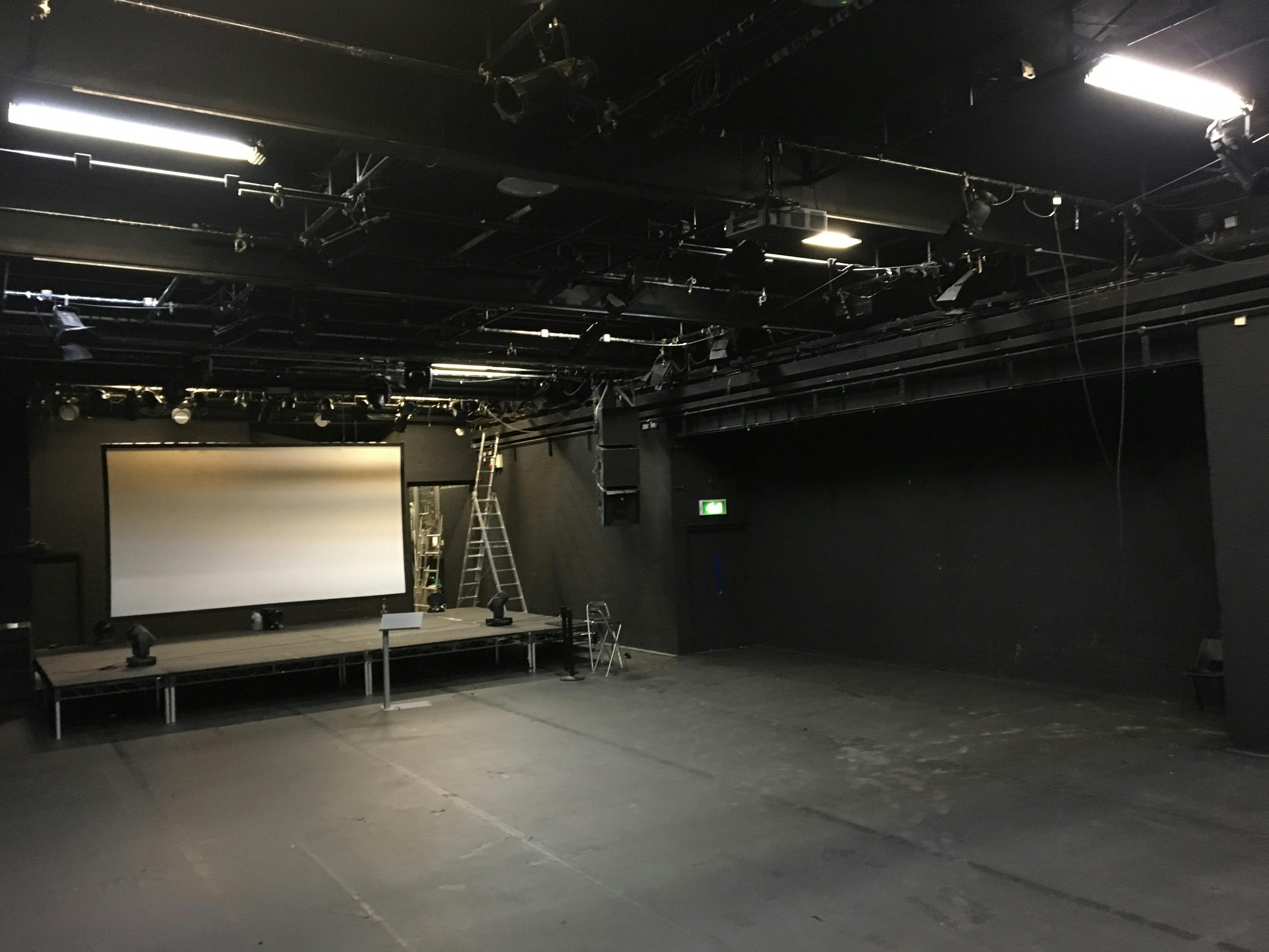 Versatile ICA Theatre with elevated stage, perfect for corporate events and performances.